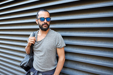 Image showing man with backpack standing at city street wall