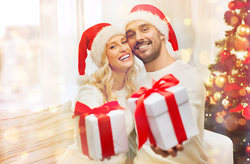 Image showing happy couple at home with christmas gift boxes