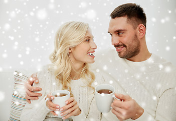Image showing happy couple with cups drinking tea at home