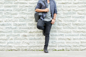 Image showing close up of man with backpack standing at wall