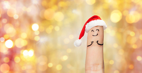 Image showing close up of one finger in santa hat over lights