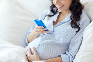 Image showing close up of pregnant woman with smartphone in bed