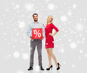 Image showing happy couple with red sale sign over snow