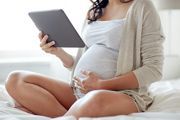 Image showing close up of pregnant woman with tablet pc at home