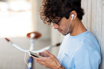 Image showing man with smartphon, earphones and bicycle