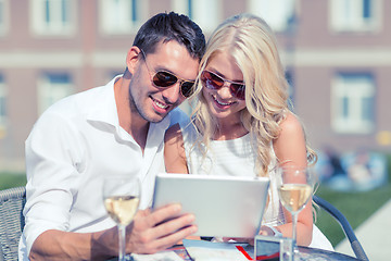 Image showing couple looking at tablet pc in cafe