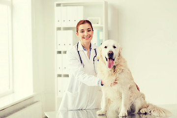Image showing happy doctor with retriever dog at vet clinic
