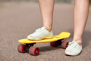 Image showing close up of female feet riding short skateboard