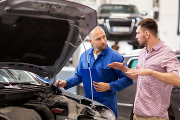 Image showing auto mechanic with clipboard and man at car shop