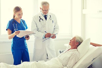 Image showing doctor and nurse visiting senior woman at hospital