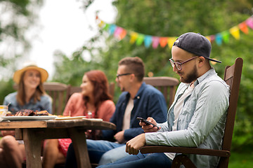 Image showing man with smartphone and friends at summer party