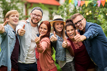 Image showing happy friends showing thumbs up at summer garden