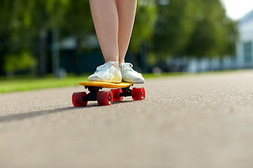 Image showing close up of female feet riding short skateboard