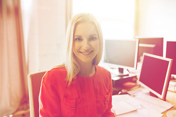 Image showing happy creative female office worker with computers