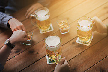 Image showing close up of hands with beer mugs at bar or pub