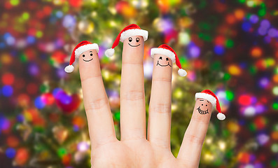 Image showing close up of hand with four fingers in santa hats