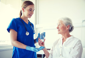 Image showing nurse giving medicine to senior woman at hospital