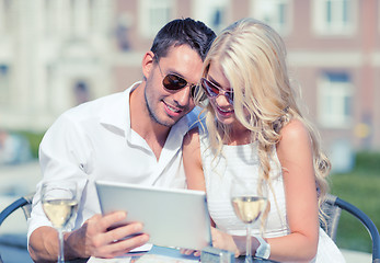 Image showing couple looking at tablet pc in cafe