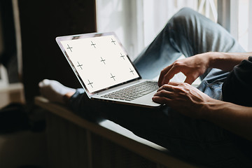 Image showing Young man typing something on a laptop