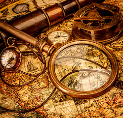 Image showing Vintage magnifying glass lies on an ancient world map