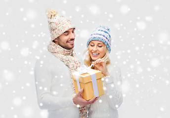 Image showing smiling couple in winter clothes with gift box