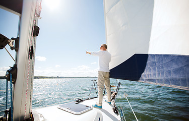 Image showing senior man on sail boat or yacht sailing in sea