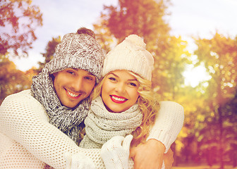 Image showing happy couple in warm clothes over autumn