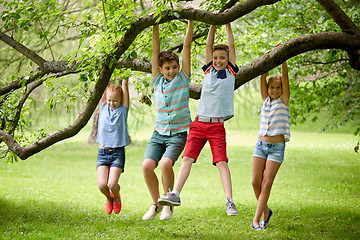 Image showing happy kids hanging on tree in summer park