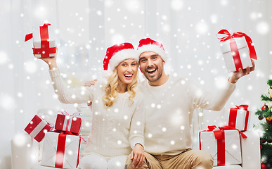 Image showing happy couple at home with christmas gift boxes