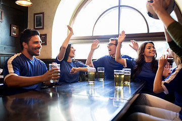 Image showing football fans with beer celebrating victory at bar