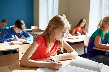 Image showing student girl with book writing school test