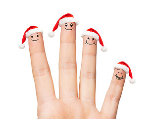 Image showing close up of hand with four fingers in santa hats