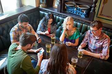 Image showing friends with smartphones and beer at bar or pub