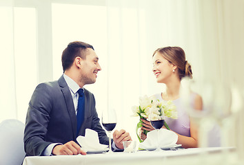 Image showing smiling man giving flower bouquet at restaurant