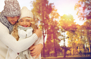 Image showing happy couple in warm clothes over autumn