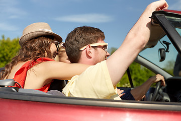 Image showing happy friends driving in cabriolet car at country