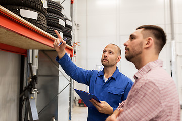 Image showing auto mechanic with clipboard and man at car shop