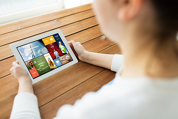 Image showing close up of woman with tablet pc on wooden table