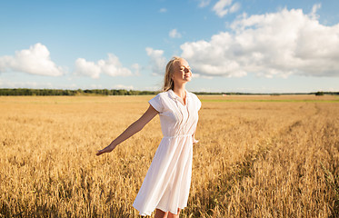 Image showing smiling young woman in white dress on cereal field