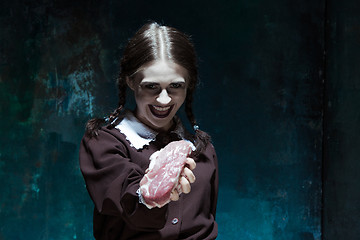 Image showing Bloody Halloween theme: crazy girl with raw meat