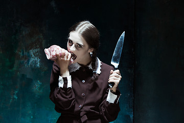 Image showing Bloody Halloween theme: crazy girl with a knife and raw meat