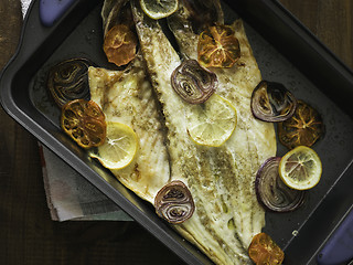 Image showing cooked sea bass with lemon, onion and tomato ready