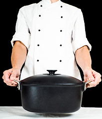 Image showing Chef holding a casserole towards, over white table clothing on b