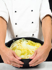 Image showing Chef in white jacket holding around a casserole of boiled cabbag