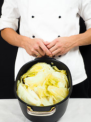 Image showing Chef in white jacket holding around a casserole of boiled cabbag