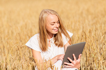 Image showing happy young woman with tablet pc on cereal field