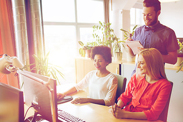 Image showing happy creative team with computer in office