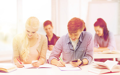 Image showing students looking into smartphone at school