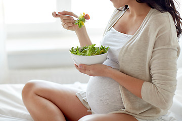 Image showing close up of pregnant woman eating salad at home