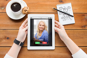 Image showing close up of woman with tablet pc on wooden table